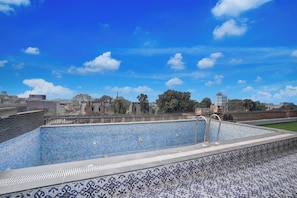 Piscina no terraço com vista para a paisagem urbana.