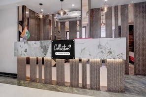 A reception desk with a marble top and vertical wooden slats. - Collection O Crawford Market (Mumbai)