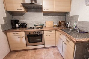 A compact kitchen with a stove, oven, and a coffee maker. - Holiday home in Rangersdorf with barbecue (Rangersdorf)