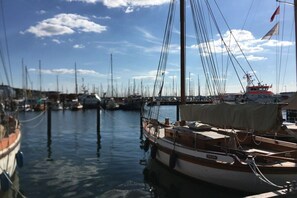 A marina with multiple boats docked, calm water, and a clear sky. - Holiday apartment in Heikendorf with Wi-Fi (Heikendorf)