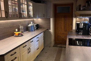 A kitchen with wooden cabinets, a coffee maker, and a fruit bowl. - Holiday apartment with 1 bedroom (Caputh)