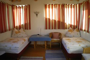 A room with two beds, a table, and a chair. - Holiday apartment in Söll with swimming pool (Söll)