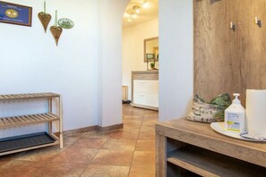 A bathroom with a wooden vanity, a shelf unit, and a mirror. - Stubai farmhouse apartment (Telfes)
