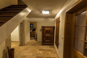 A hallway with a wooden staircase, a fireplace, and a door with glass panels. - "Small climbing hut" (Bad Schandau OT Krippen)