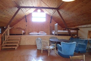 A loft-style room with a wooden ceiling, a small table with chairs, a bunk bed, and a window providing natural light. - Cabin in Drognitz with swimming pool (Drognitz)