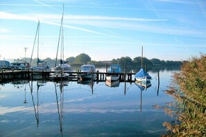 A marina with boats docked at wooden piers, calm water, and a clear sky. - High tide on the beautiful Baltic Sea (Schönhagen)