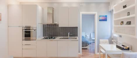 A modern kitchen with white cabinetry, a built-in oven, and a gas stove.