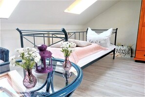 A bedroom with a bed, a glass table with vases, and a sign on the wall. - Holiday apartment with 3 bedrooms (Schönhagen)