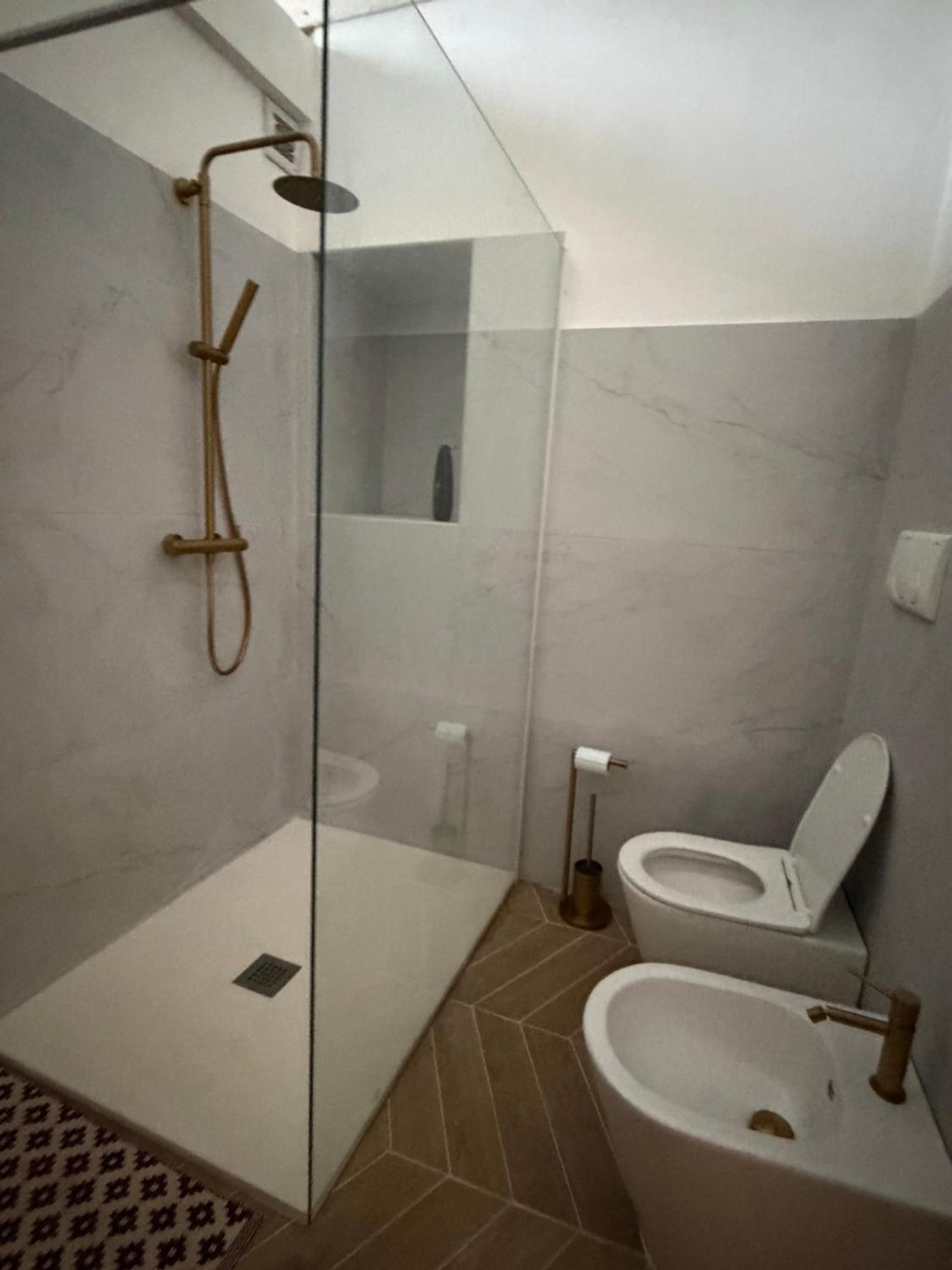 Une salle de bain avec une douche à parois de verre, des toilettes et un lavabo.
