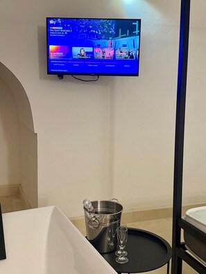 Televisor fixat a la paret que mostra un canal esportiu.