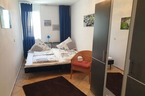Une chambre à coucher avec un lit, une chaise, une commode et un miroir.