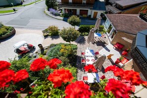 A residential area with a paved driveway, a parked lawnmower, and a patio area with outdoor furniture. - Apartment with 1 bedroom (Heiligenblut am Großglockner)
