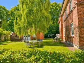 A brick building with a garden patio, a table, and chairs. - Holiday Apartment With 1 Bedroom (Wyk auf Foehr)