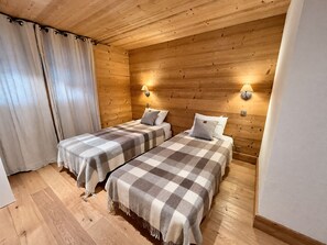 A room with two beds, wooden walls, and a wooden ceiling. - New Listing (Les Allues)