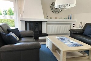Ein Wohnzimmer mit Kamin, zwei Sofas, einem Couchtisch und einer Wanddekoration.
