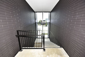 Eine moderne Treppe mit schwarzen Geländern, die zu einer Glastür führt.