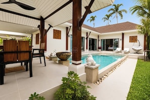 A modern outdoor pool area with a dining setup and lounge chairs.