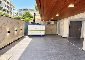 A modern indoor corridor with a Koel air purifier, marble walls, and a tiled floor. - Stavora Suites (Gurugram)