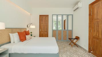 A hotel room with a bed, a nightstand, a lamp, a window with a view, and a wardrobe.
