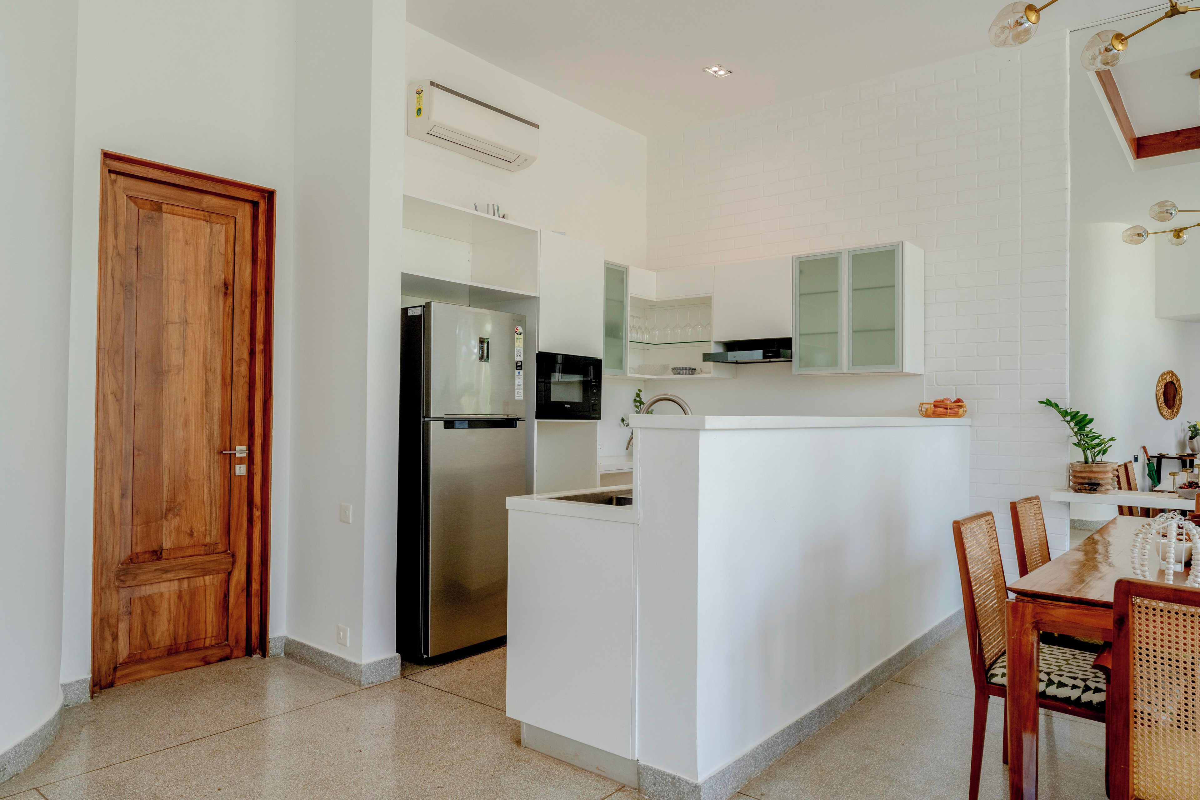 A modern kitchen with a built-in refrigerator, a microwave, and a white countertop.
