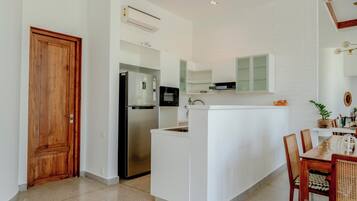 A modern kitchen with a built-in refrigerator, a microwave, and a white countertop.
