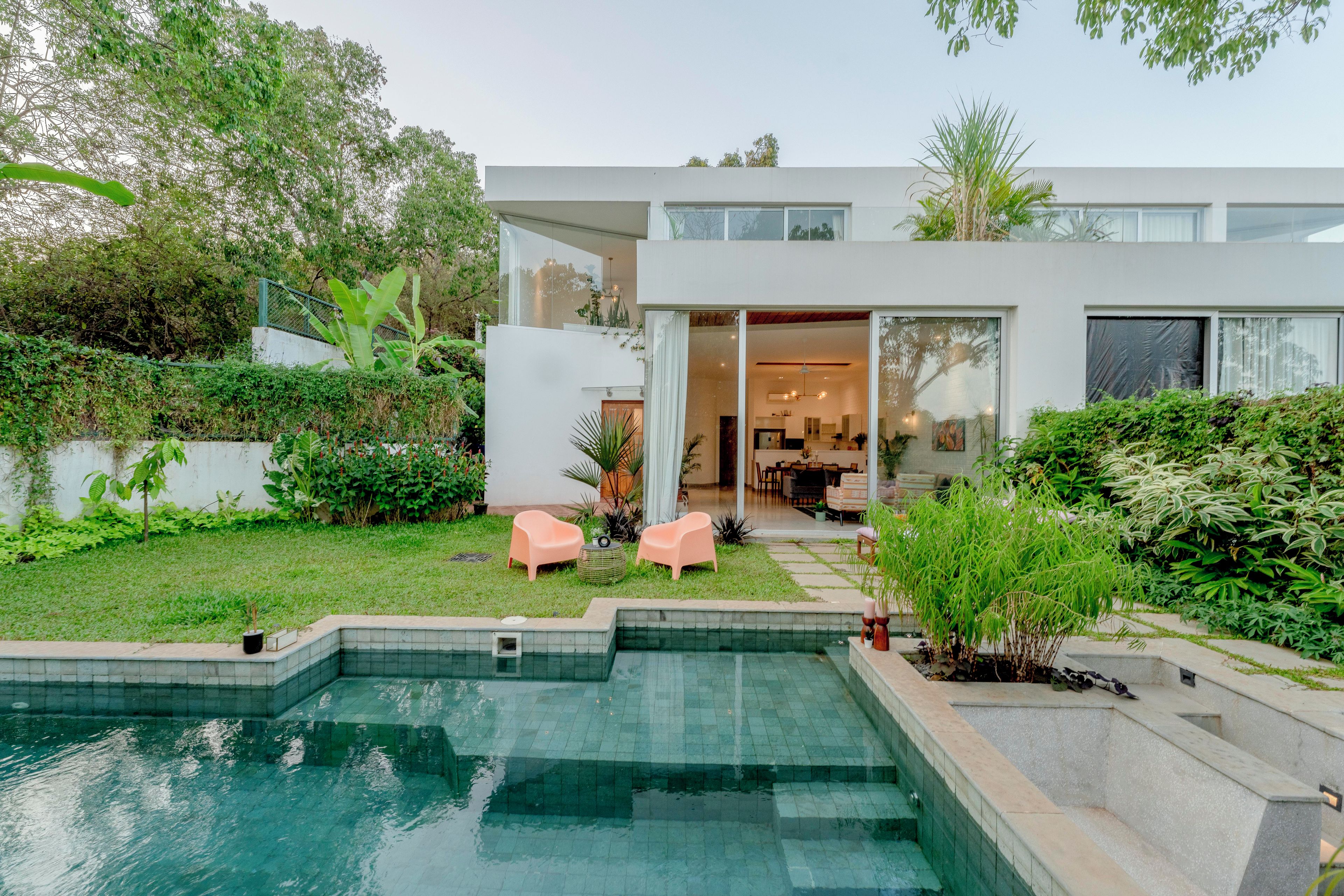 Uma casa moderna com piscina, área de estar ao ar livre e um jardim bem cuidado.