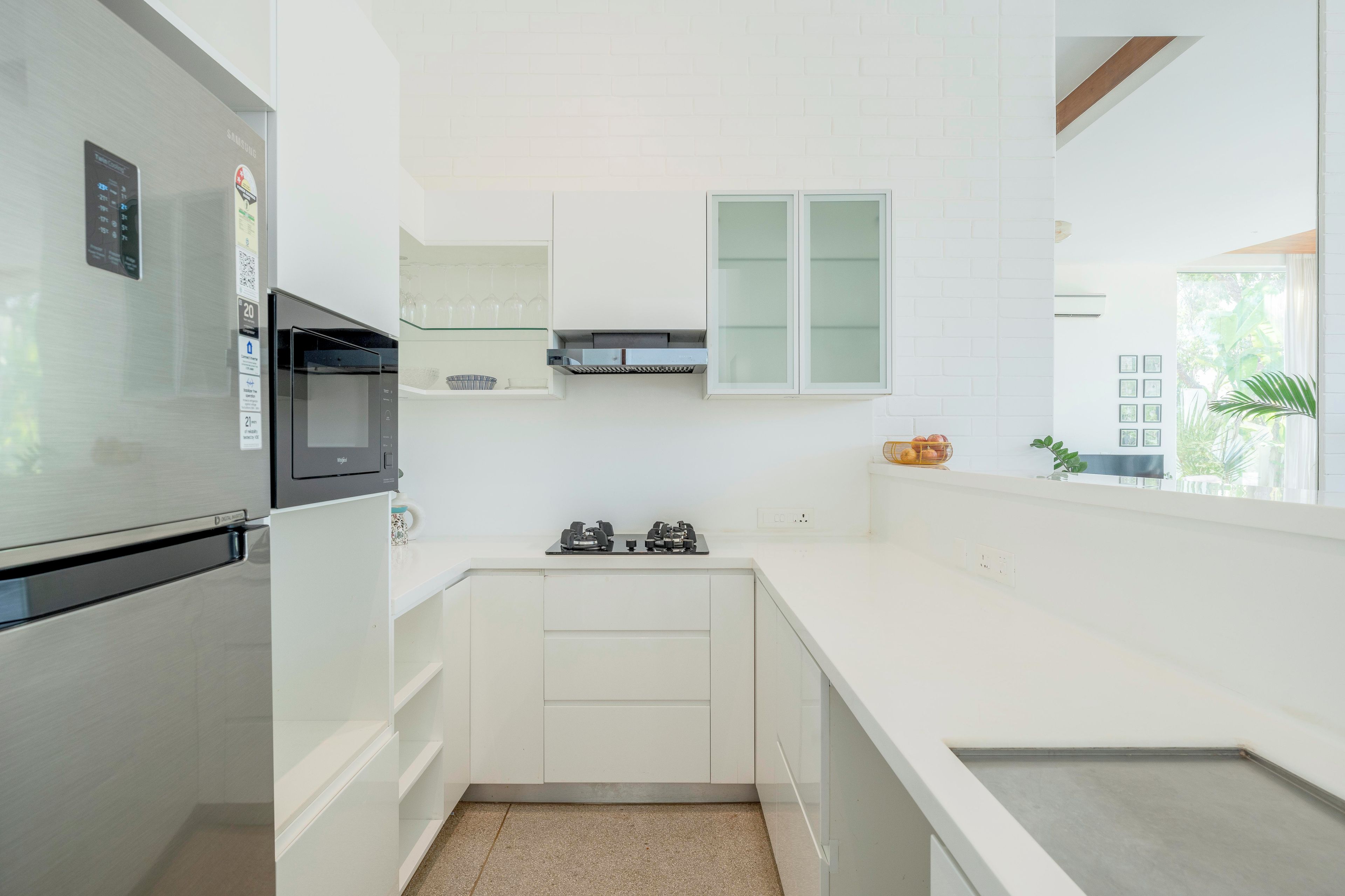 A modern kitchen with a built-in microwave, a stainless steel refrigerator, and a gas stove.