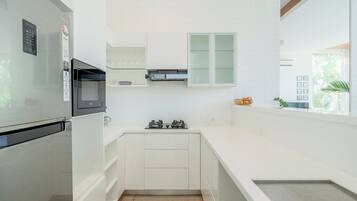 A modern kitchen with a built-in microwave, a stainless steel refrigerator, and a gas stove.
