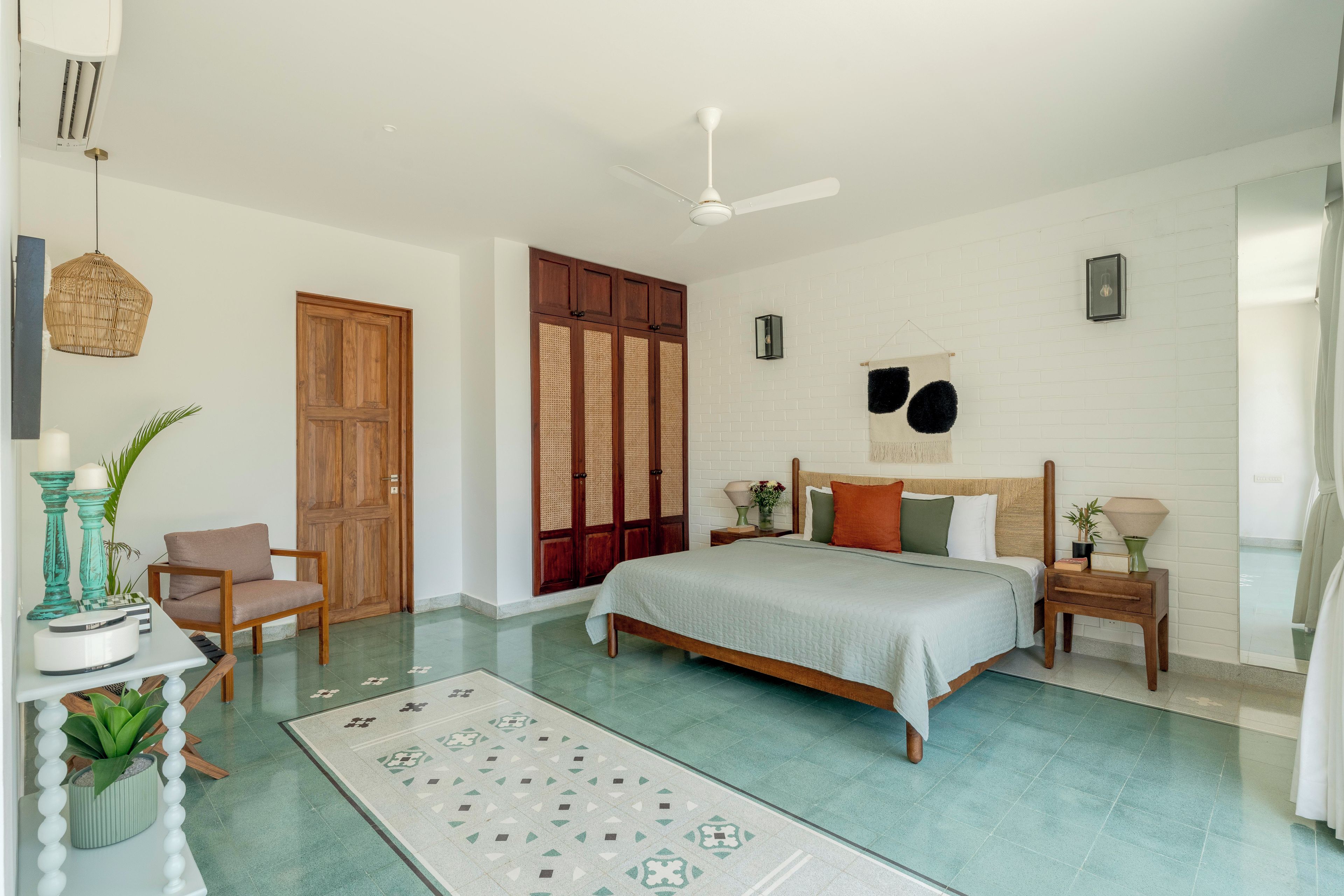 A bedroom with a bed, nightstands, a chair, a large window, and a ceiling fan.