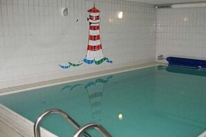 A swimming pool with a tiled wall featuring a lighthouse mural. - Badestraße 40a - Holiday Apartment 1 (Wyk auf Föhr)