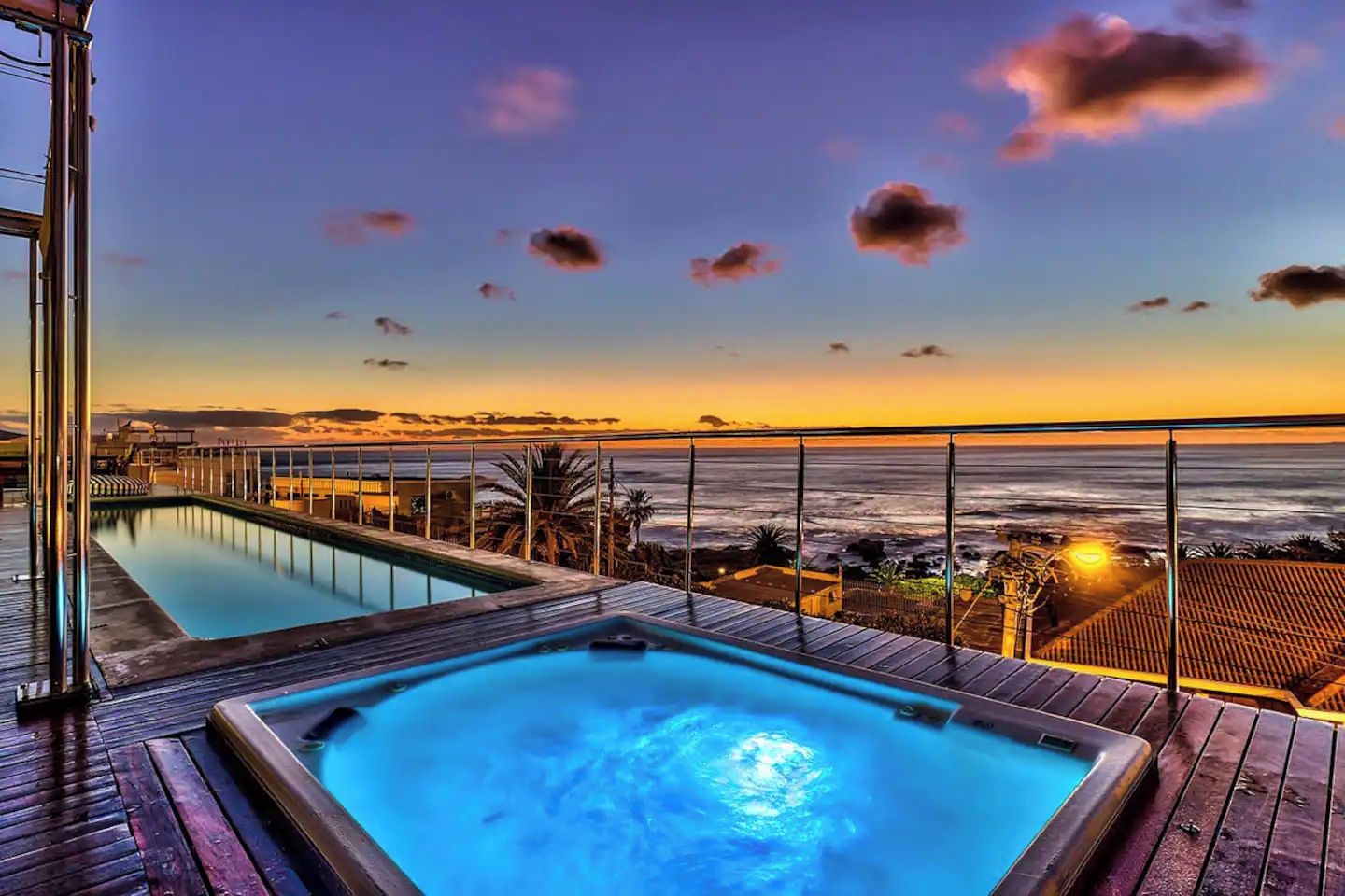 Ein Poolbereich mit Blick auf das Meer bei Sonnenuntergang.