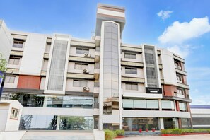Un edificio de varios pisos con un diseño arquitectónico moderno, que presenta un elemento vertical destacado y un letrero que indica que se trata de una casa townhouse de servicio de la empresa.