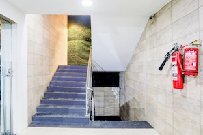 Una escalera con un extintor fijado a la pared.