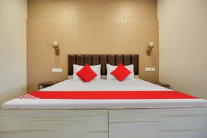 Habitación de hotel con una cama grande, dos mesitas de noche y una lámpara de pared.