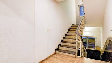 A staircase with a handrail, wooden steps, and a window at the top.