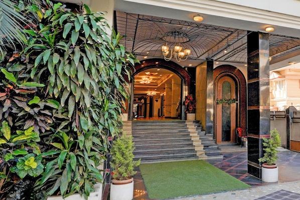 A hotel lobby with a large indoor plant, a chandelier, and a checkered floor. - Townhouse Civil Aviation HAL Road (Bangalore)