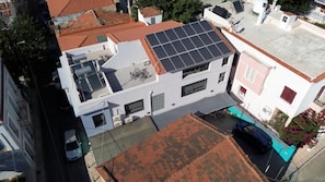 A residential building with a solar panel roof, a visible garage, and a street view. - Data Maisonettes and More (Chios)
