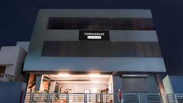 A building with a sign reading 'TOWNHOUSE' and a gated entrance.