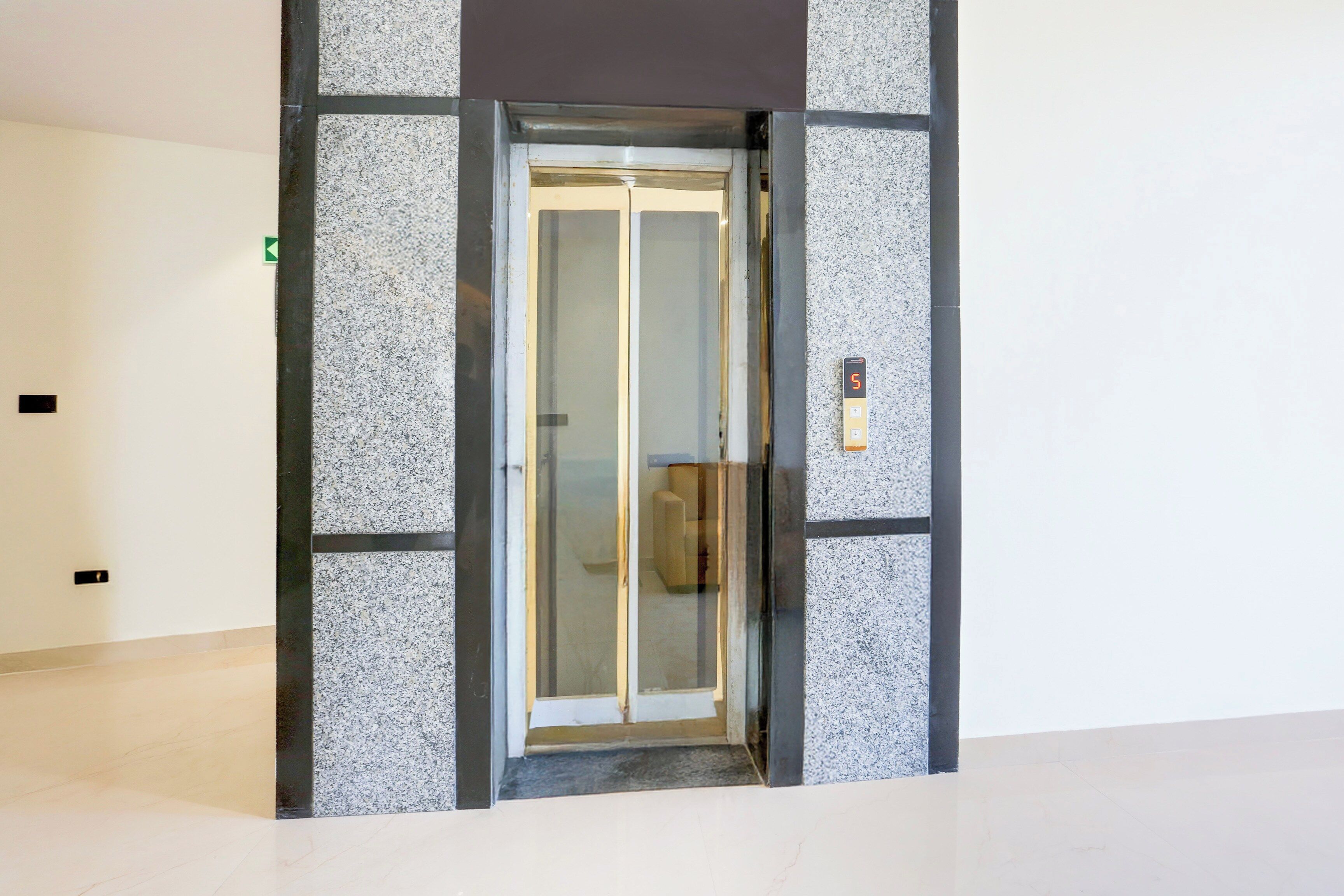 A modern elevator with a glass door and a digital display.