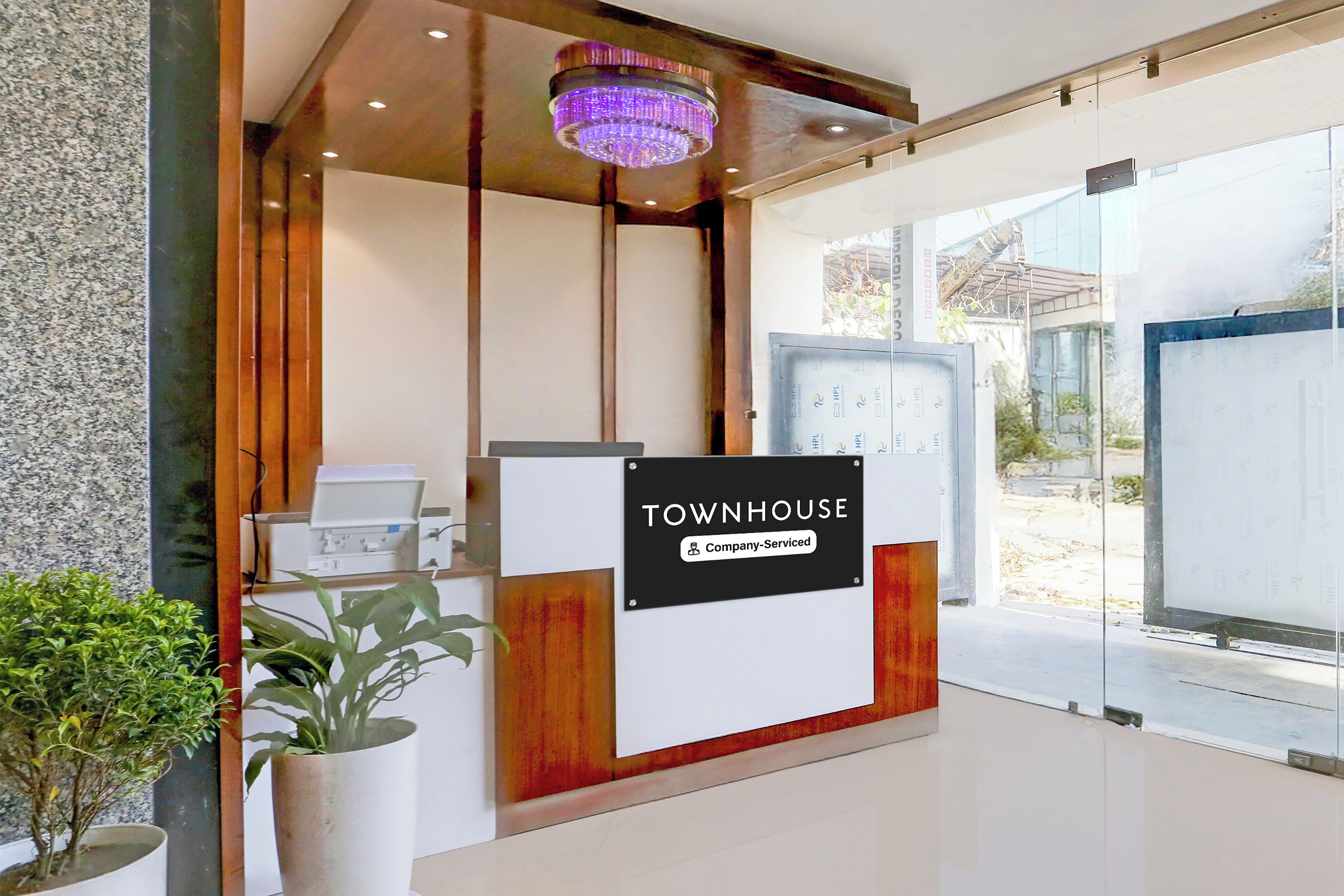 Een receptiebalie met een bord waarop 'TOWNHOUSE Company Serviced' staat.