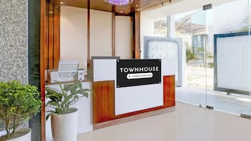 Un comptoir d’accueil avec une pancarte indiquant : « Services de l’entreprise TOWNHOUSE ».