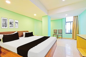 A hotel room with a bed, a chair, a desk, and a window with curtains. - Townhouse Ameerpet Balkampet Road (Hyderabad)