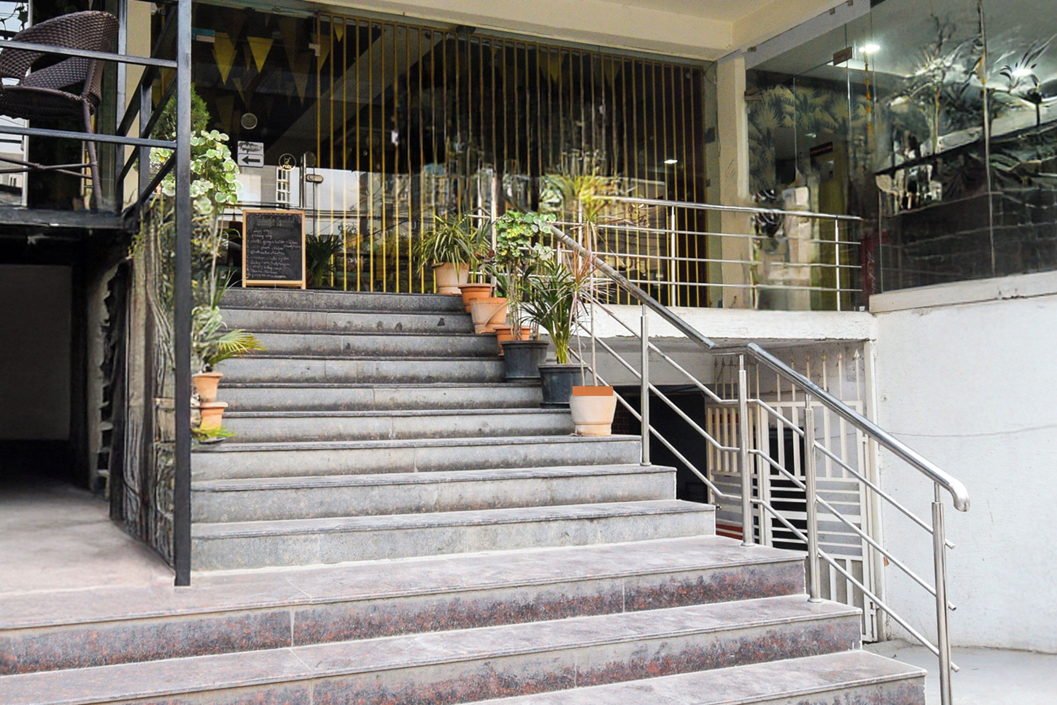 Una escalera con barandillas metálicas que conduce a la entrada de un edificio.