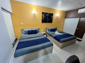A hotel room with two beds, a painting on the wall, and an air conditioning unit. - HIDDEN GEM (Jamtha)