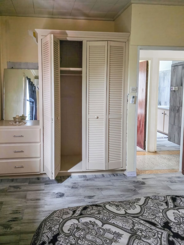 A room with a wardrobe, a dresser, and a patterned rug.