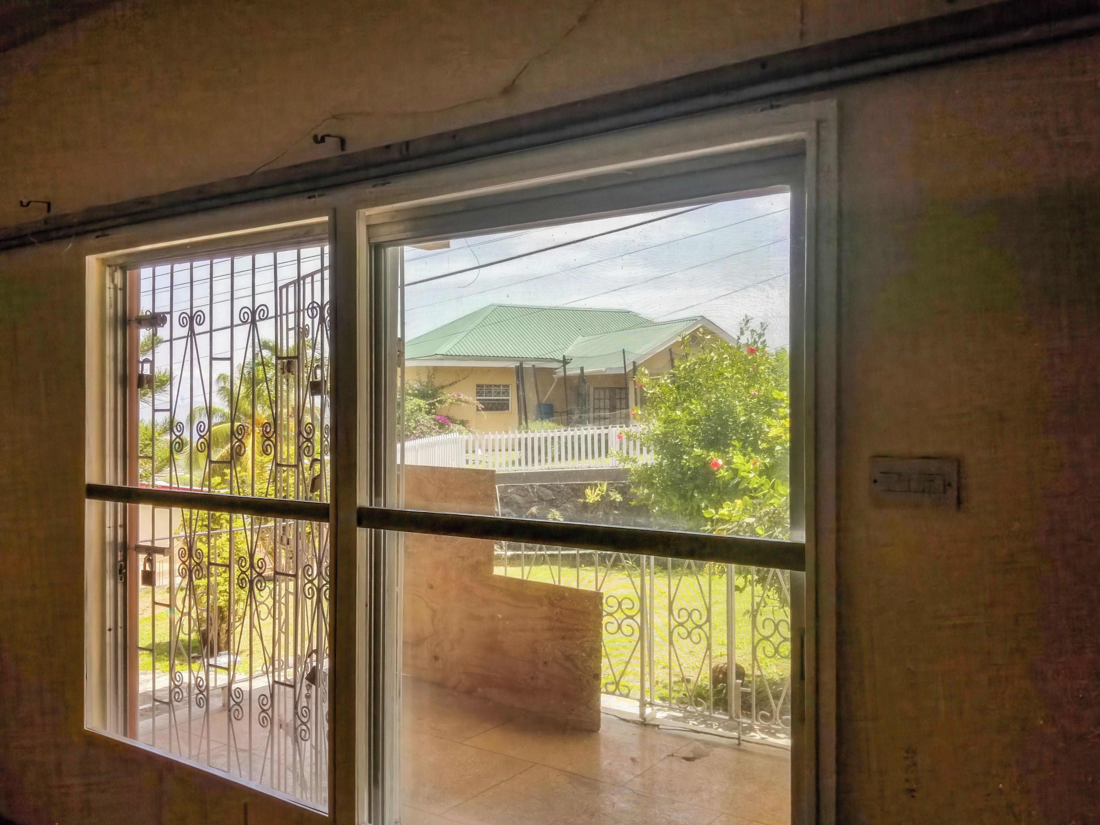 A room with a sliding glass door leading to a balcony with a metal railing.