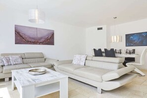 A modern living room with a sofa, a coffee table, and artwork on the walls. - New Love - Süderstr. 18c (Sylt)