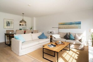 A modern living room with two sofas, a coffee table, a lamp, and artwork on the walls. - Ostertresker Sea Garden (Tinnum - Sylt)