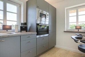 Una cocina moderna con electrodomésticos integrados, una ventana con vistas y una encimera con fregadero.