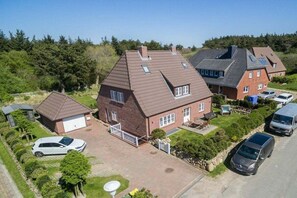A residential area with multiple houses, a driveway, and parked cars. - Holiday apartment in Sylt with 2 bedrooms (Sylt Westerland)